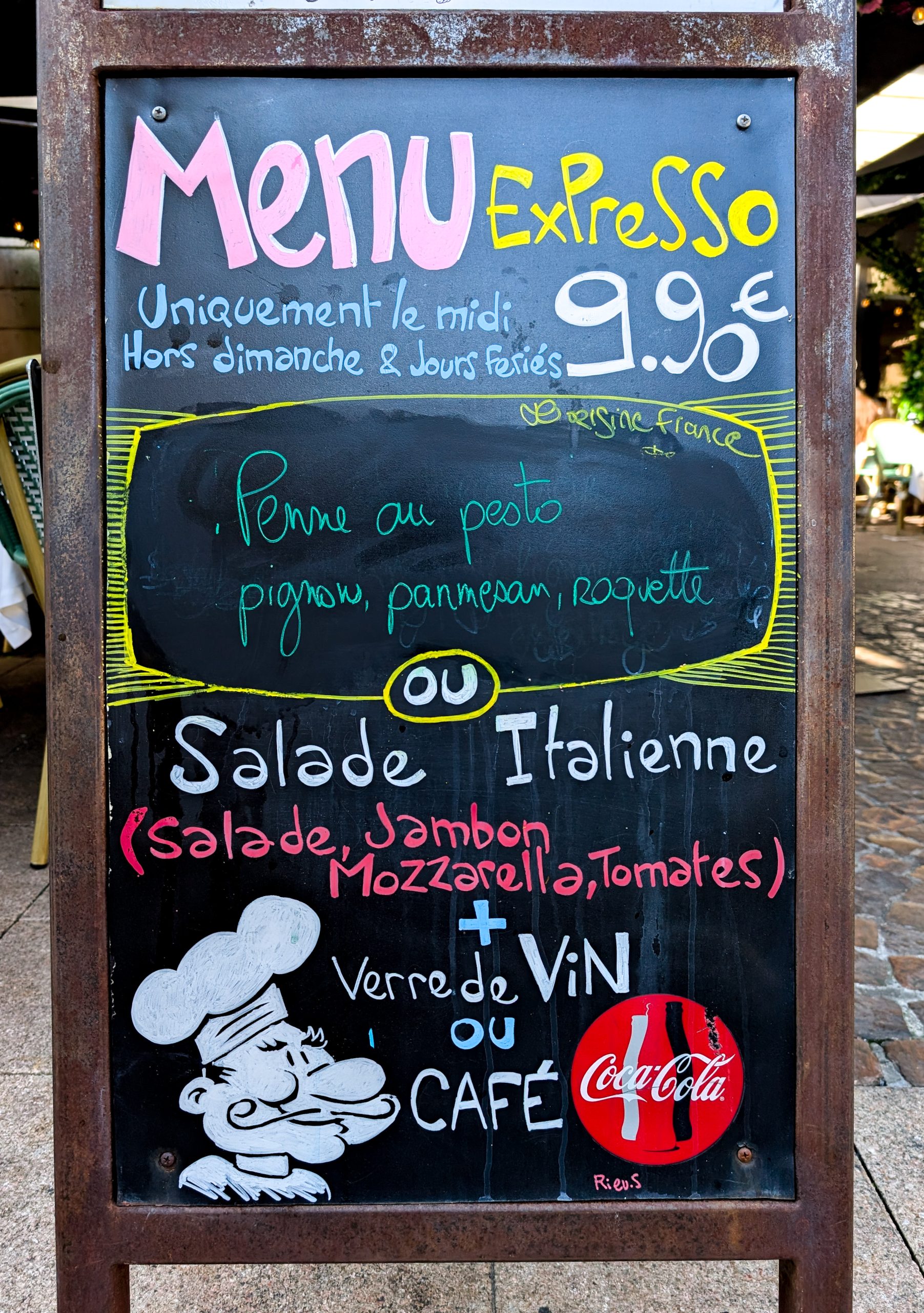 Grande ardoise 'Menu du Jour' colorée Grande ardoise 'Menu du Jour' peinte avec un personnage de chef et des couleurs vives.