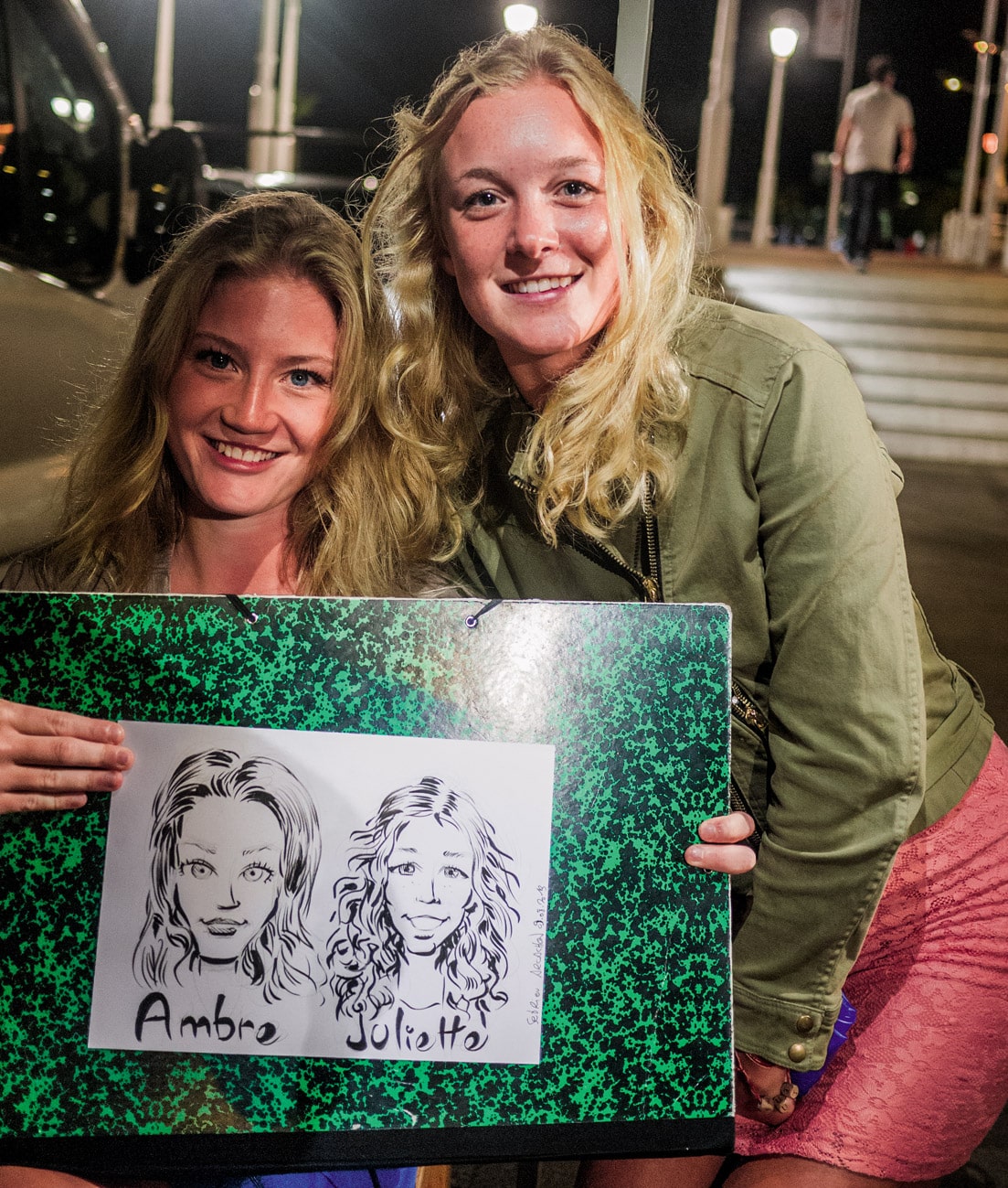 Deux vacancières belges posant avec leur portrait illustré sur la jetée Thiers à Arcachon