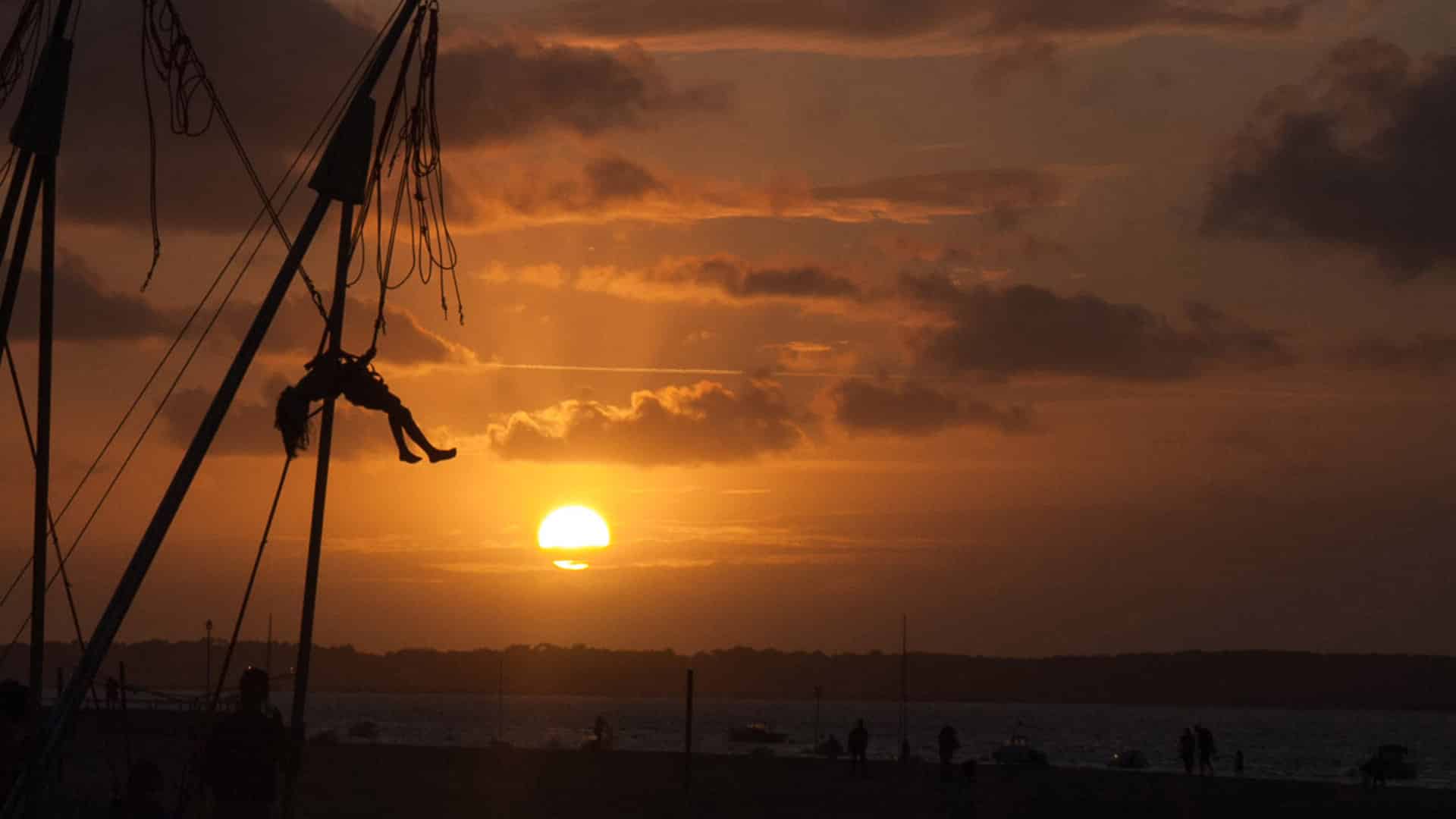 Coucher de soleil orange sur le front de mer d'Arcachon, silhouette en suspension au-dessus du Bassin