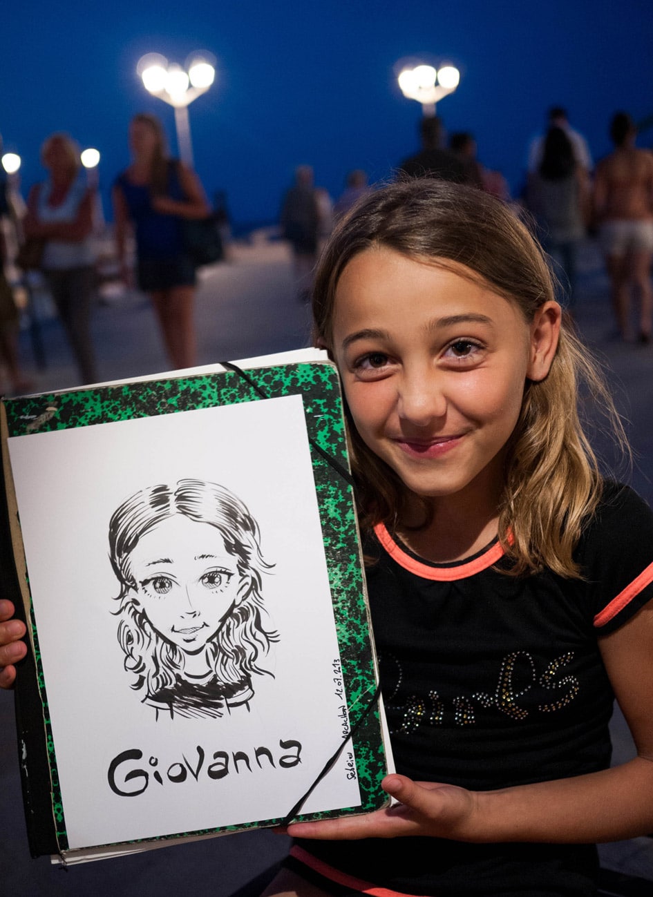 Enfant posant avec son portrait illustré sur la jetée Thiers à Arcachon