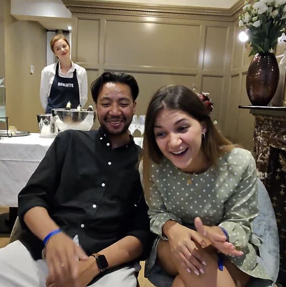 Invitée hilare découvrant son portrait illustré, soirée dans un hôtel de luxe parisien